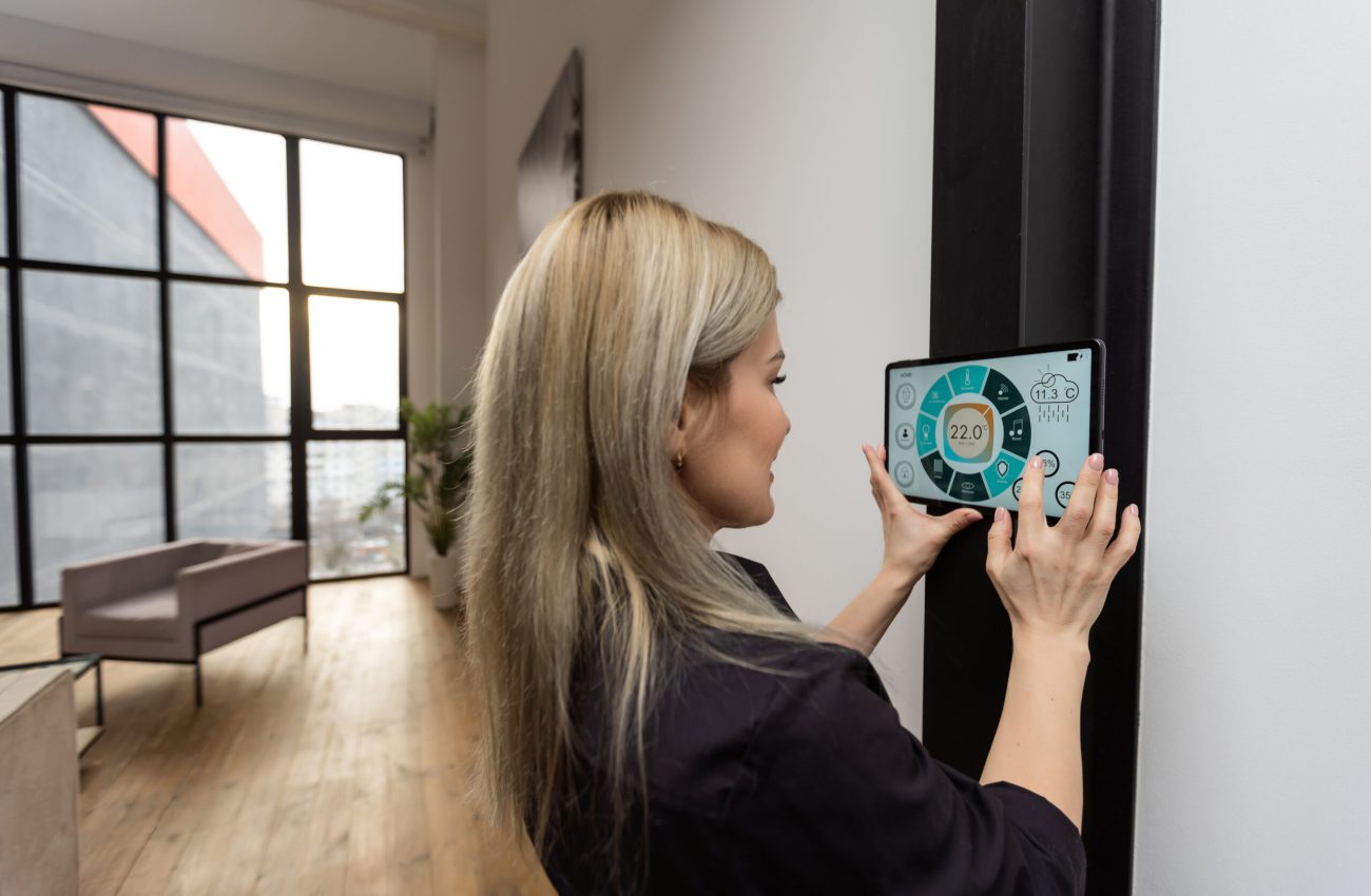 Female hands holding digital tablet with smart home app.